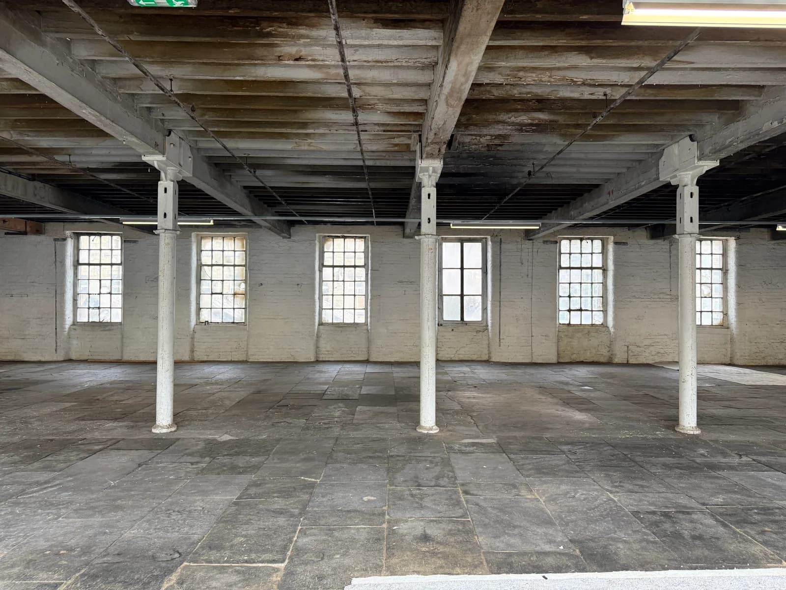 Open mill floor with original iron pillars and windows
