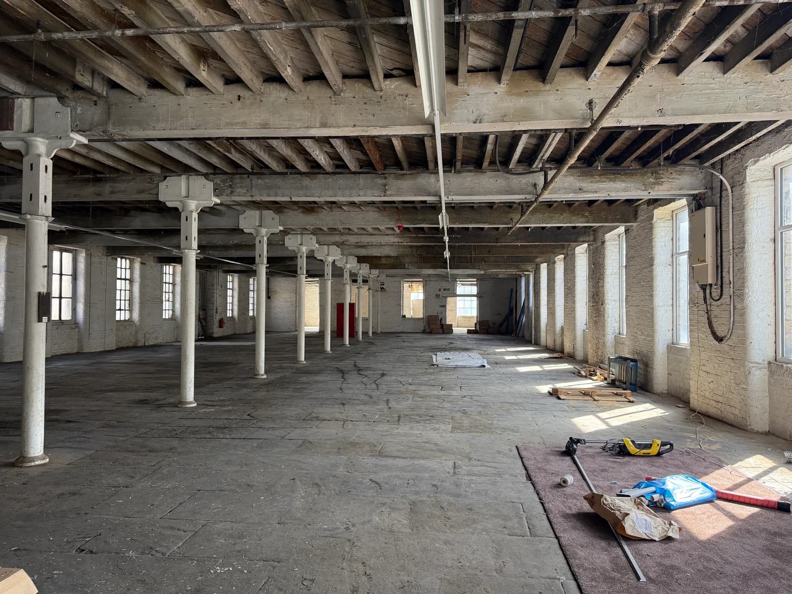 Long view through the empty mill with pillars and exposed ceiling beams