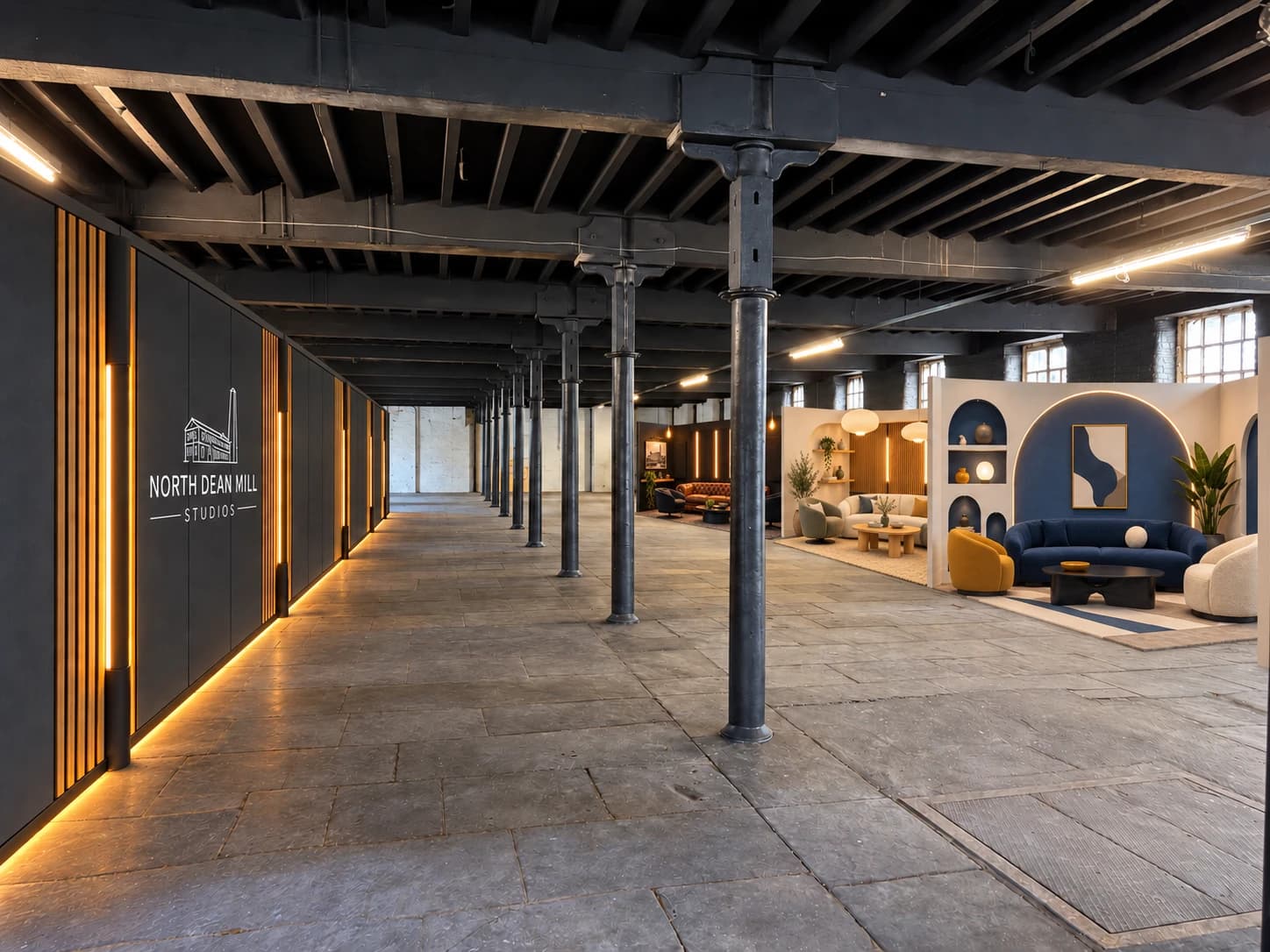 The long feature wall behind the mill pillars, opposite the finished black, oak and heritage-blue podcast sets